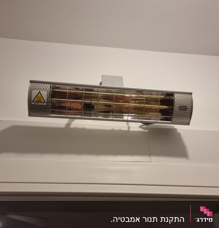 תנור חימום חשמלי מותקן על קיר לבן
